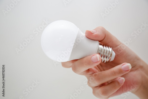 Lampada led de energia branca na mão de uma pessoa segurando.