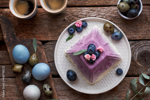 Traditional Easter Orthodox curd cake with blueberry. Traditional Easter cottage cheese dessert. Flowers, blueberry, eggs. Wooden background, top view, horizontally. photo