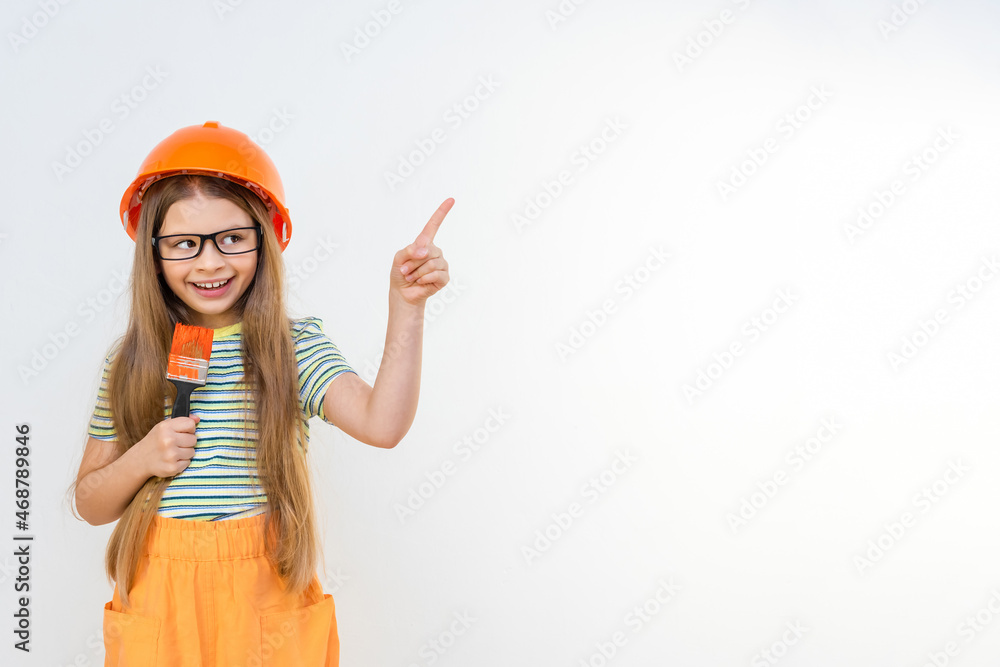 Renovation in the children's room. The little girl points her finger to the side. Renovation in the children's room. The little girl points her finger to the side.