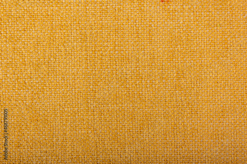 Factory fabric of brown color with yellow threads interspersed. Close-up long and wide texture of natural red fabric. Fabric texture of natural cotton or linen textile material. Red canvas background