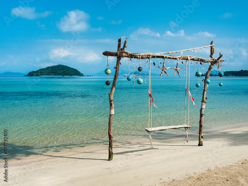 Scenic white sand beach tropical island with relax wooden swing and turquoise sea against blue sky in summer. Koh Mak Island, Trat, Thailand.