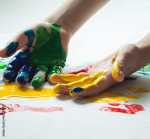 Children's hands in colorful paints.