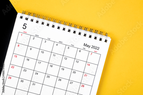 May 2022 desk calendar on yellow and black background.