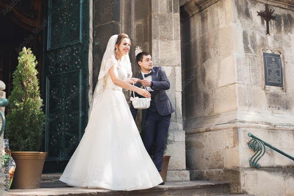 Fototapeta premium Perfect couple bride, groom posing and kissing in their wedding day