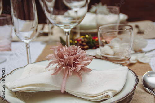 Close-up napkin on dish glass and two different cups on shiny tablecloth in Christmas season. Christmas decoration for dining tables