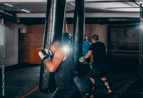 Strength male boxer training with punching bag. Boxing exercise