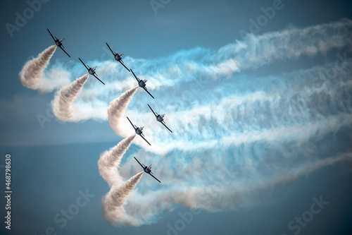 Division of planes during the air show. Contrails.