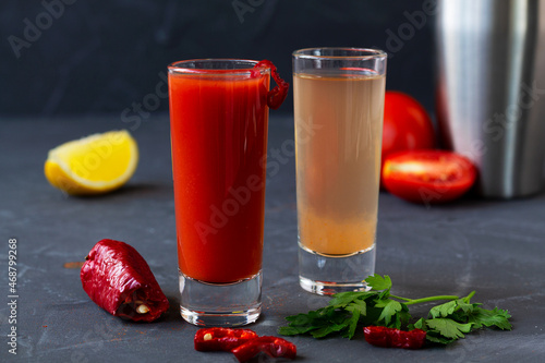 close-up two tequila shots on black background. Sangrita is Mexican traditional alcohol drink with tequila, tomato juice, hot spices, chili pepper and lime.copy space.alcoholic drink. vodka photo