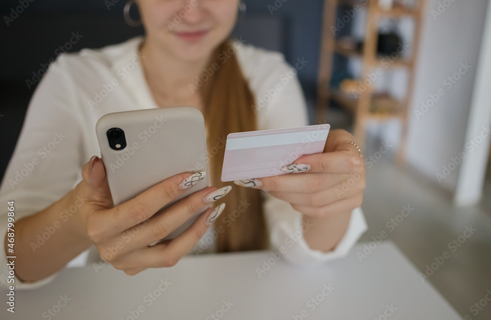 Young girl holding a mobile phone and a credit card in her hands Young girl holding a mobile phone and a credit card in her hands