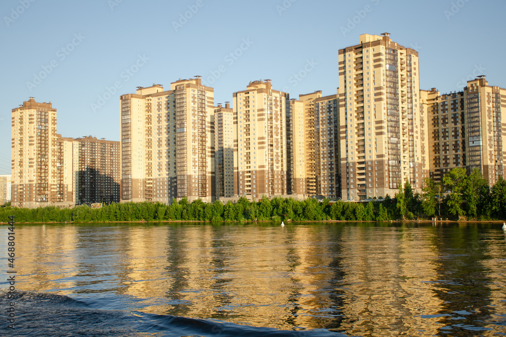 New buildings on the banks of the Neva River in the city of St. Petersburg. View from the water on a summer sunny day.