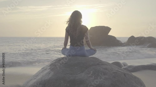 Meditating on a rock at sunset photo