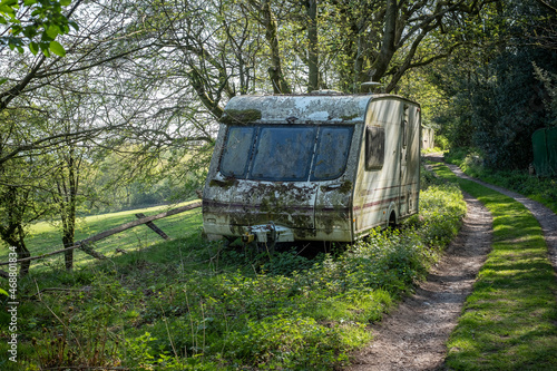 Abandoned touring caravan on the roadside verge of a farm track, Boundary, Staffordshire, England, UK.