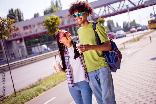 Photo portrait smiling couple wearing glasses drinking milkshakes walking in the city