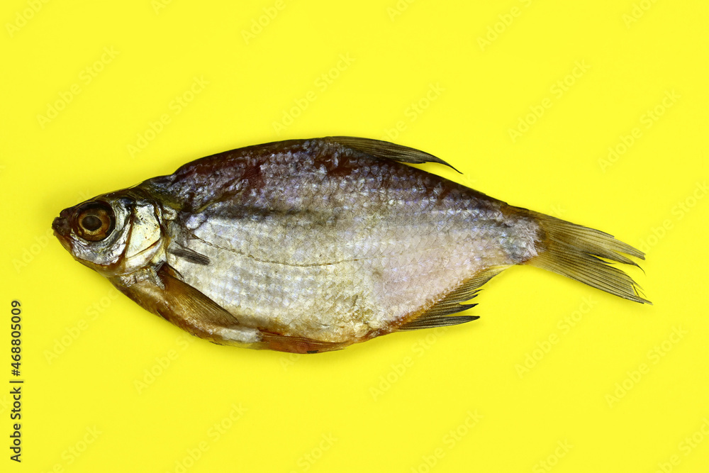 dried fish on a yellow background close-up