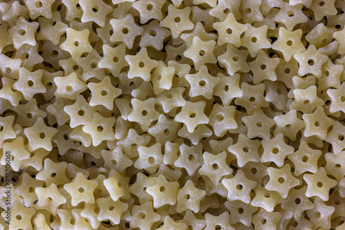 Close-up of durum wheat star shaped pasta with hole, baby food and first course concept. Stelline prepares quickly.