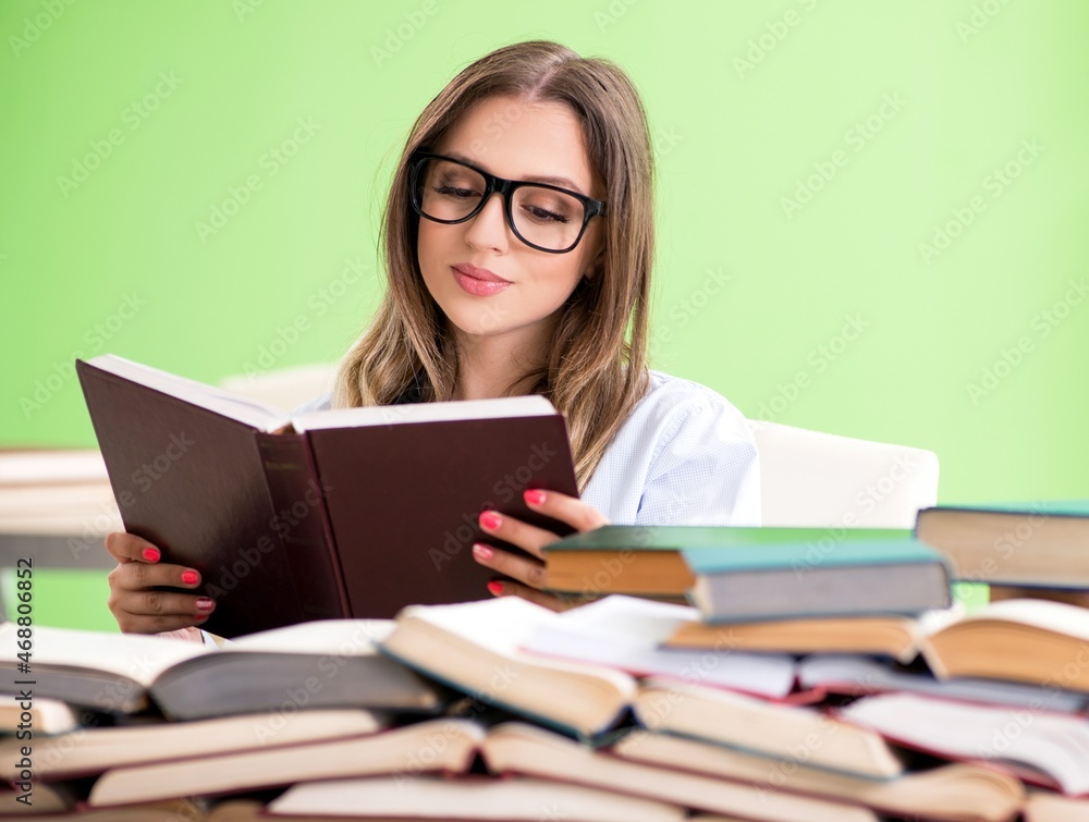 Young female student preparing for exams with many books Young female student preparing for exams with many books
