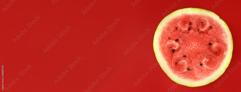 half of fresh watermelon on a red background. Horizontal banner. Copy space for text half of fresh watermelon on a red background. Horizontal banner. Copy space for text