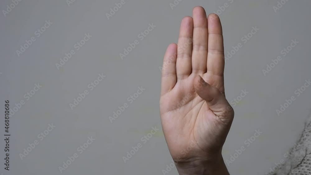 Signal for help concept: slow motion of a woman that shows how to make the gesture to ask help silently Signal for help concept: slow motion of a woman that shows how to make the gesture to ask help silently