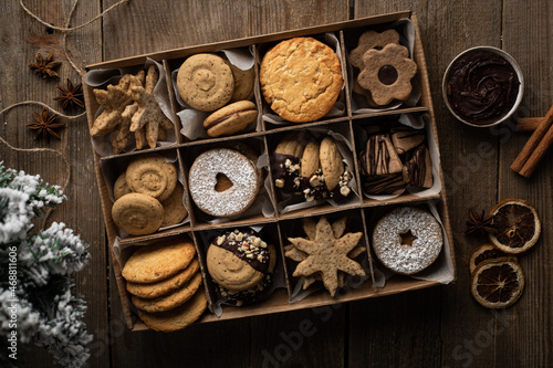 Fototapeta Boîte de biscuits sablés de Noël assortis sur une table avec sapin et décoration