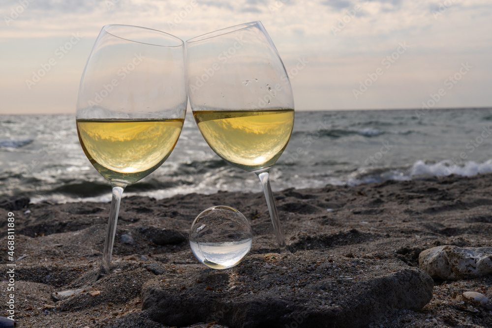 Romantic glass of white wine, on the sea beach. Wine tasting and relaxation at the resort Romantic glass of white wine, on the sea beach. Wine tasting and relaxation at the resort
