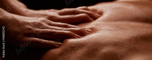 Hands of a girl on a tanned male back close-up. Horizontal banner