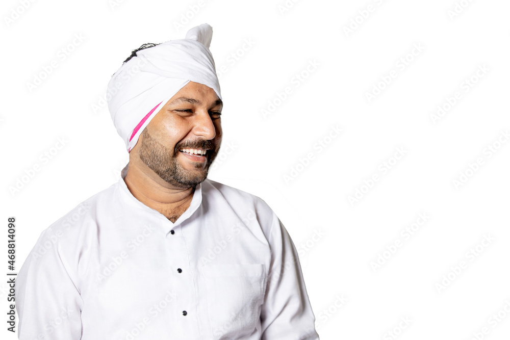 Close up of overjoyed young Indian rural man wearing kurta and turban standing over isolated white background looking away, excited happy village male have fun smile at joke, humour concept. Close up of overjoyed young Indian rural man wearing kurta and turban standing over isolated white background looking away, excited happy village male have fun smile at joke, humour concept.