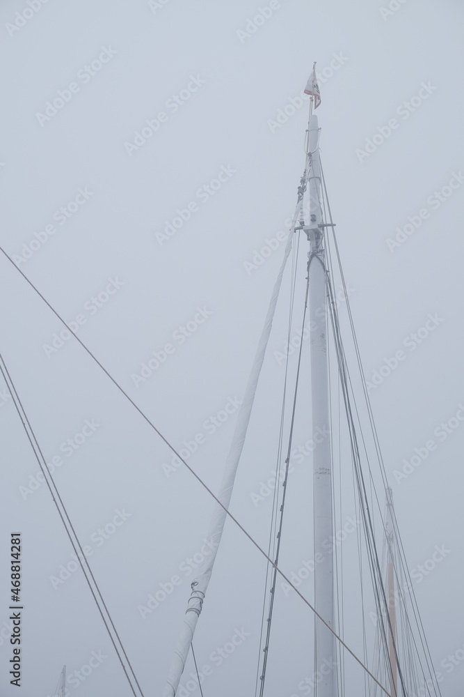 Sailboat masts in heavy fog in a safe protected harbor. Sailboat masts in heavy fog in a safe protected harbor.