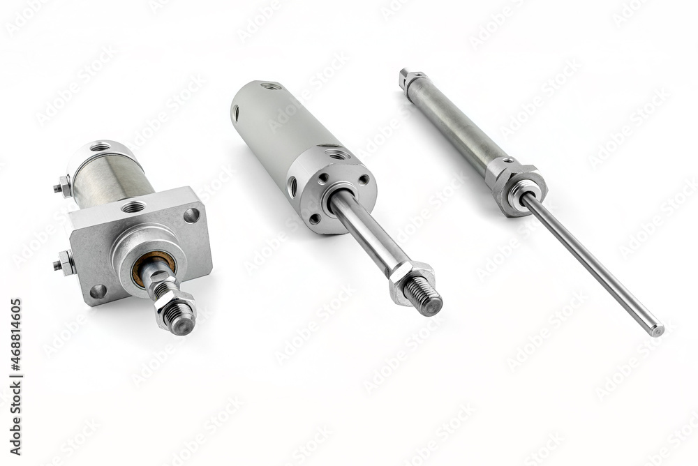 Three pneumatic air cylinders with thread and nut at the end, visible screw-in air dampers, isolated on a white background. Three pneumatic air cylinders with thread and nut at the end, visible screw-in air dampers, isolated on a white background.