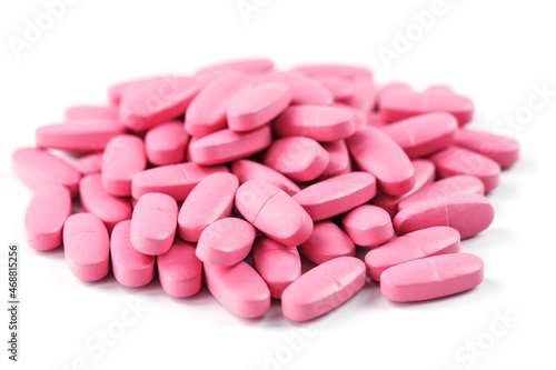 Pink vitamin pills for women on a white background.