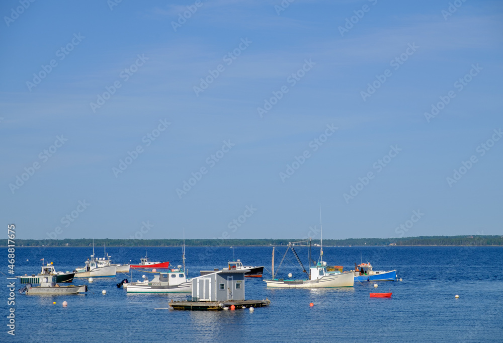 Anchored colorful red white and blue Lobster Boats on a perfect summer day sitting at harbor