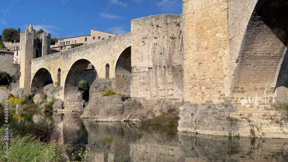 Banyoles European medieval village castle defense wall bridge towers old town tourist filming with fluid gimbal blue sky sunny day Banyoles European medieval village castle defense wall bridge towers old town tourist filming with fluid gimbal blue sky sunny day