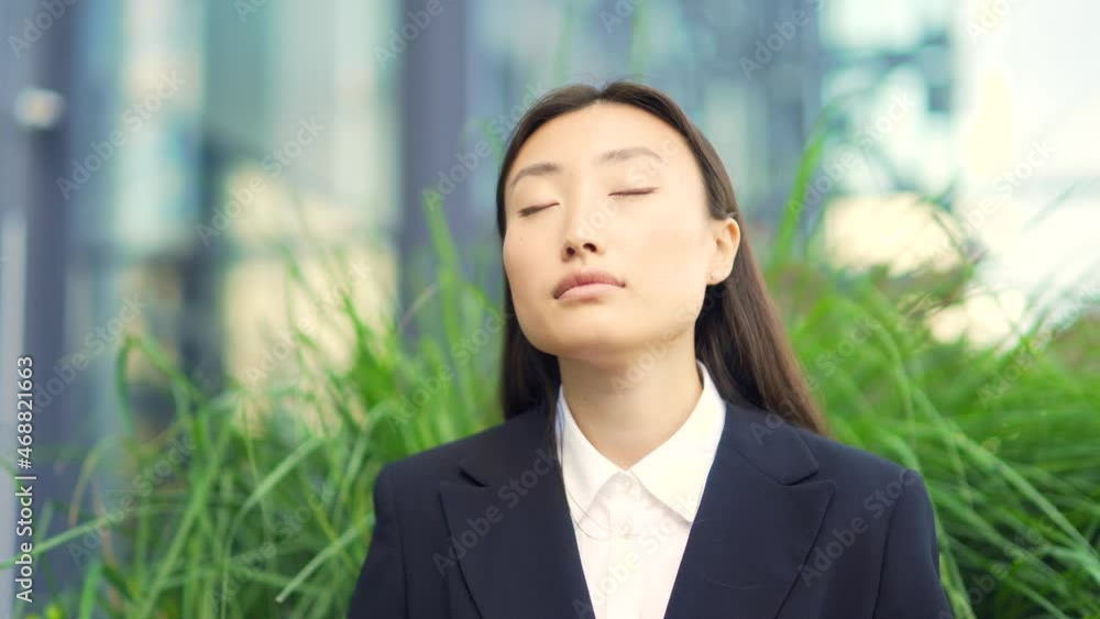 Asian female office worker relax, meditates outdoor sitting on a bench on urban background a city park resting a break Business woman employee in formal suit, eyes closed. Silence, tranquility calm Asian female office worker relax, meditates outdoor sitting on a bench on urban background a city park resting a break Business woman employee in formal suit, eyes closed. Silence, tranquility calm