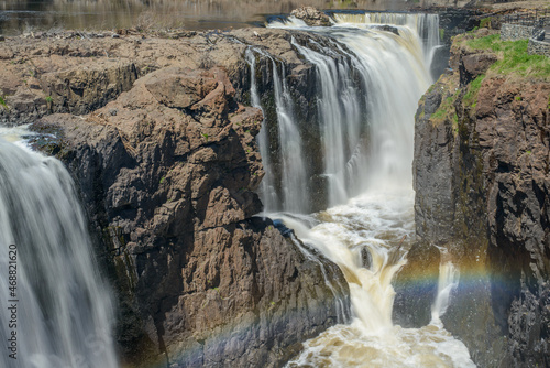 Rainbow created by the mist coming off the Great Falls over the Basaltic cliffs