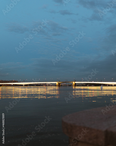 Evening lights of the bridge in the city on the river