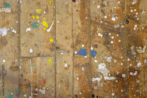 Colorful boat paint droplets on a pine wood plank woodshed floor photo