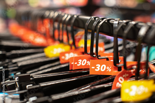 Wallpaper Mural Discount sale tags 30% off, on hangers with clothes in casual, home or sport clothing store. Fashion concept, discount season, black friday, offline shopping, gimmicks, holiday sales. Side view Torontodigital.ca