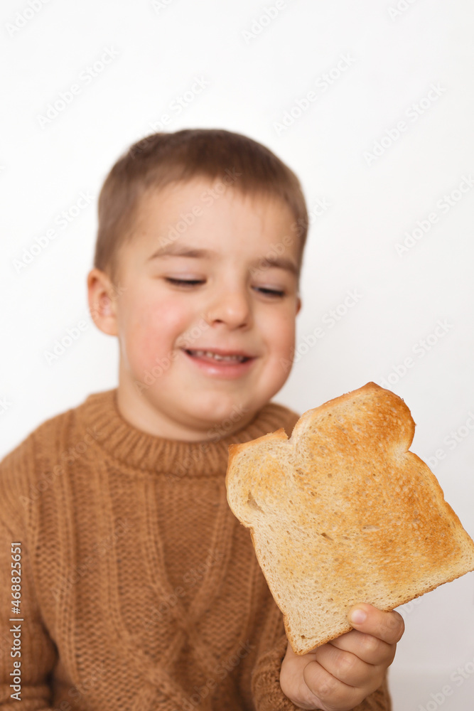 Children and gluten. Preschool boy with toasted bread. Gluten intolerance by kids. Copy space on bread for text or symbol. Children and gluten. Preschool boy with toasted bread. Gluten intolerance by kids. Copy space on bread for text or symbol.