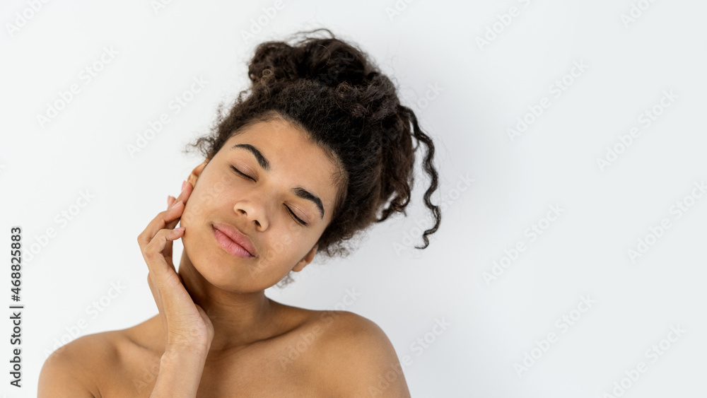 Obraz premium Young african american woman touching her perfect facial skin