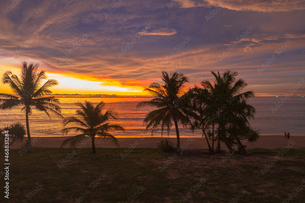 aerial view scenery sunset above coconut trees during colorful .cloud in sunset on Karon beach Phuket Thailand. .Scene of Colorful red light in the sky background. aerial view scenery sunset above coconut trees during colorful .cloud in sunset on Karon beach Phuket Thailand. .Scene of Colorful red light in the sky background.