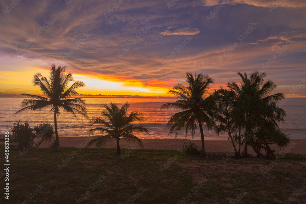 aerial view scenery sunset above coconut trees during colorful .cloud in sunset on Karon beach Phuket Thailand. .Scene of Colorful red light in the sky background. aerial view scenery sunset above coconut trees during colorful .cloud in sunset on Karon beach Phuket Thailand. .Scene of Colorful red light in the sky background.