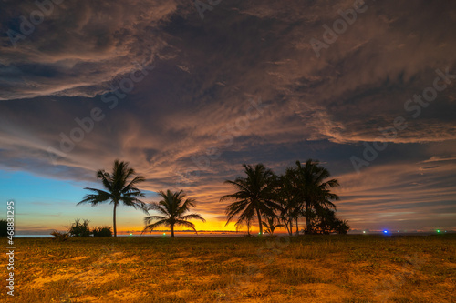scenery sunset above coconut trees during colorful .cloud in sunset on Karon beach Phuket Thailand. .Scene of Colorful red light in the sky background.