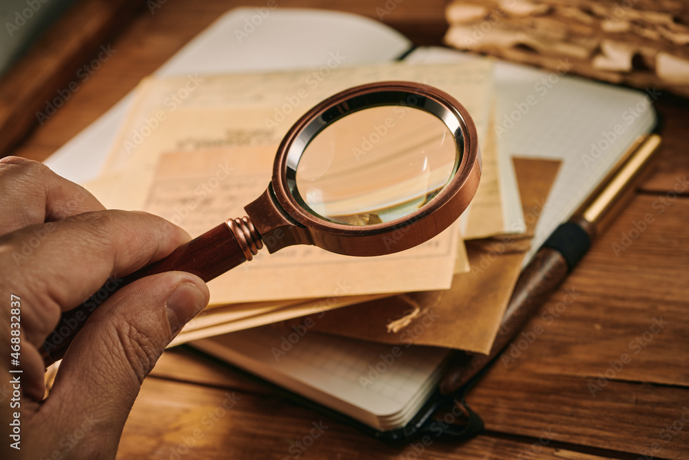 Fototapeta premium Exploring antique documents through the magnifying glass