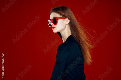 pretty woman wearing sunglasses fashion posing hairstyle red background