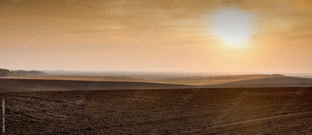 agricultural land in the sunset world, lines of hills on the horizon