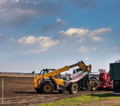 the loader lifts a bag with seeds  sowing