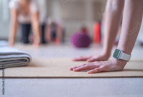 Close-up of the hands of a yoga instructor  placed in front of her students.
