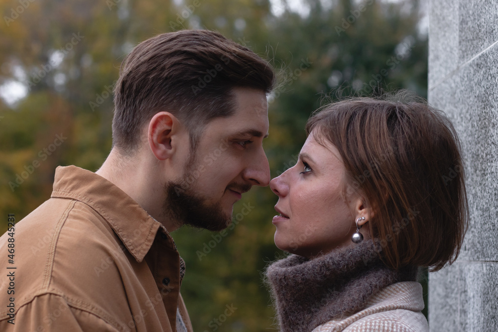 Young man and young woman couple stand face to face before kissing Young man and young woman couple stand face to face before kissing