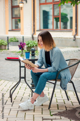 Confident beautiful girl with a notebook on the terrace. Business style. Psychologist