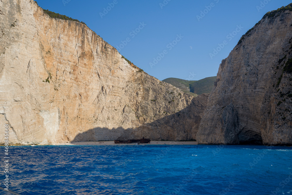 View of the contraband shipwreck on th ebeach surrounded by impenetrable clifs and turquoise waters of the Aegean Sea