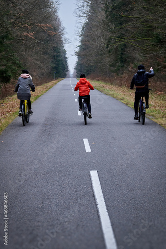 Family cycling in autumn park. Dad, Mom, son.